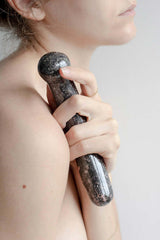 Chakrubs Anahata Curve Rhodonite Wand held close to the body, emphasizing its graceful curve and smooth texture.