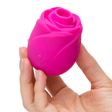 Romp Rose 2.0 Air Suction Stimulator in a hand, showcasing its elegant rose shape and vibrant pink color.