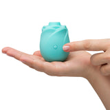 Romp Glow Air Suction Rose Massager held in a hand, showcasing its rose-inspired design and silicone material.