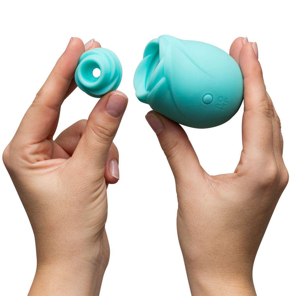 Romp Glow Air Suction Rose Massager held in hands with removable attachment, showcasing its innovative design and body-safe silicone.