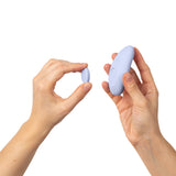 Image of hands holding the Dame Lay Panty Vibrator With Remote Control in two sizes for comparison.