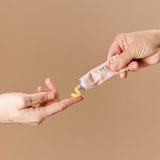 Hand applying Sex Au Naturel Vulva Balm Soothing Moisturizer from a tube, showcasing its soothing properties.