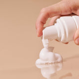Hand dispensing foam from the bottle of Sex Au Naturel Prebiotic Intimate Wash Gentle Foam.