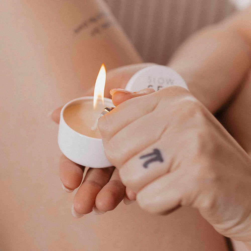 Bijoux Indiscrets Slow Sex Massage Candle being lit, ready for a sensual massage experience.