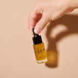 Slow Sex Anal Soothing Oil Before And After Care in a dropper bottle held by a hand.