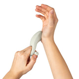 Person holding Dame Hug Vibrating Couples Ring Fog for demonstration of its unique design and fit.