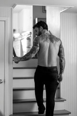 Man with tattoos walking up stairs wearing male power mesh 2.0 mini short black M.