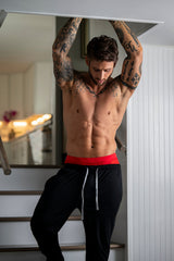 Male Power Mesh 2.0 Mini Short Red XL on display worn by a tattooed man in a stylish indoor setting.