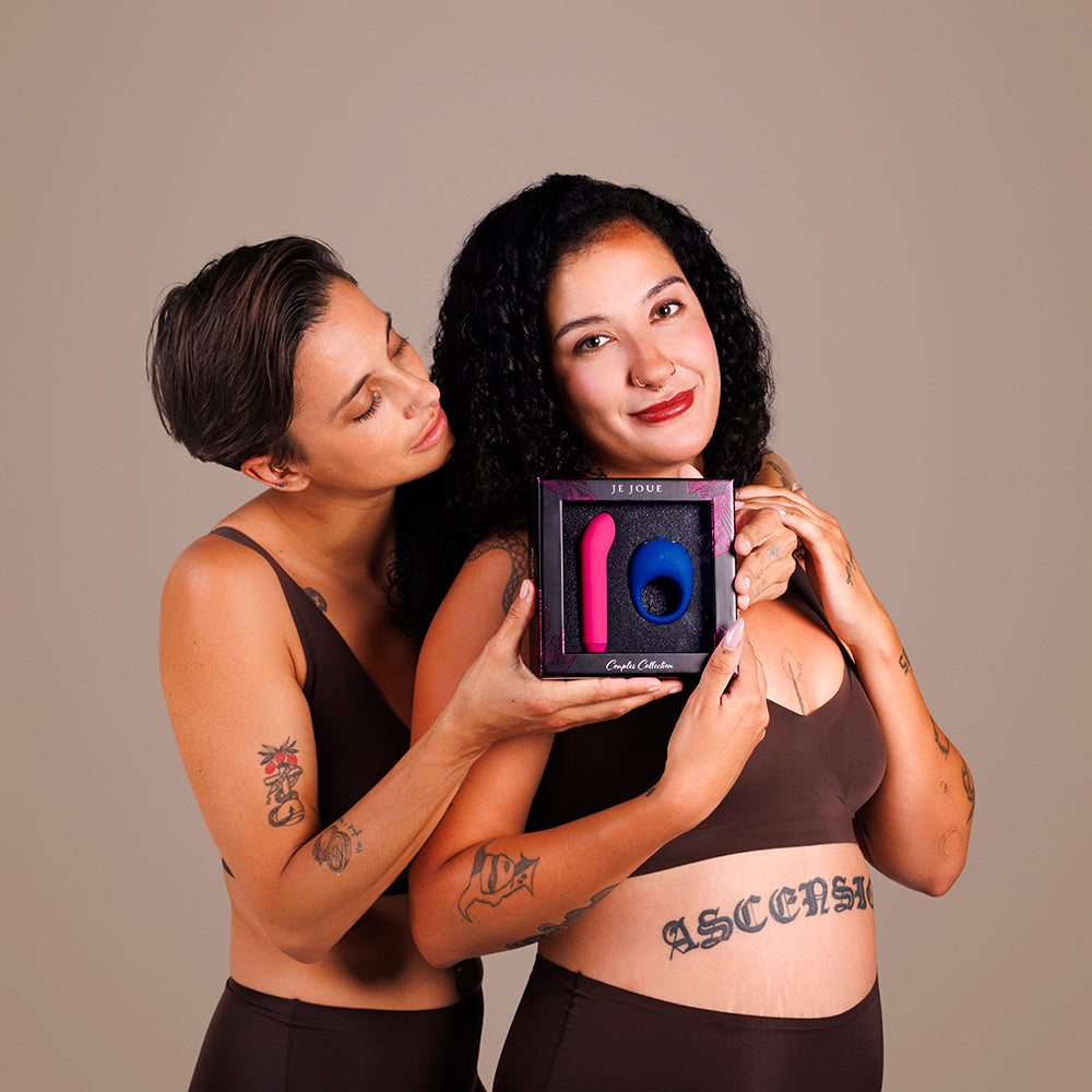Je Joue Couple's Collection Vibrator Gift Set displayed by two models, showcasing intimate pleasure products in an elegant package.