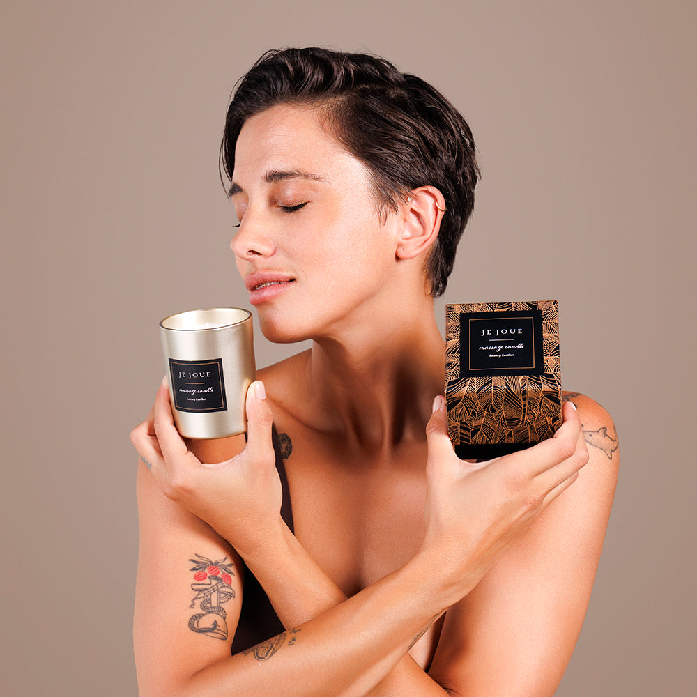 Je Joue Luxury Leather Massage Candle 160g held by a woman enjoying its aroma, showcasing luxury and relaxation.