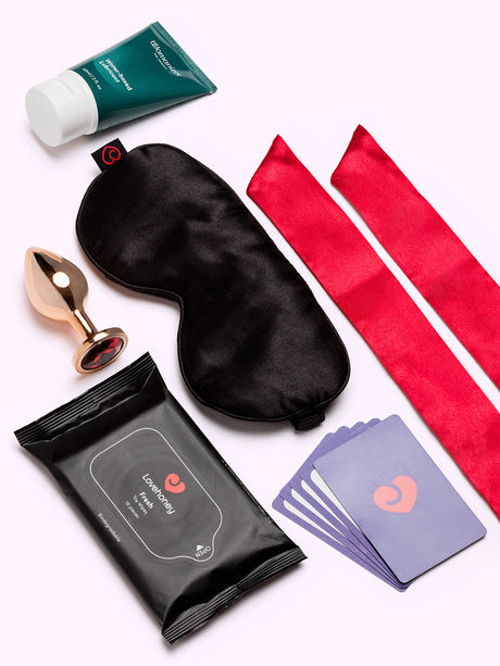 Lovehoney X We-Vibe 7 Day Romance Advent Calendar contents including mask, cards, lubricant, and accessories.