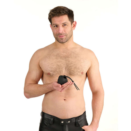 A shirtless man holding the Prowler Red Vibrating Ball Bag, showcasing its design and features.