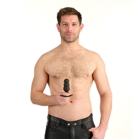 A man holding the Prowler Red Bubble Rechargeable Plug With Remote, showcasing its playful design and smooth surface.