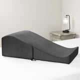 Liberator Flip Ramp With Slip Cover Lush Black positioned on a bed, offering ergonomic support and versatile use.