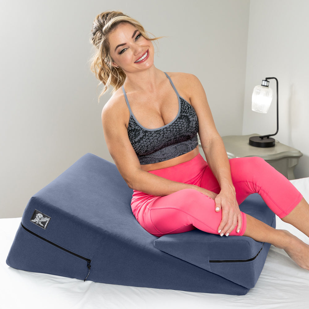 Liberator Wedge & Ramp Sex Combo Original Size Blue being demonstrated by a smiling woman in activewear.