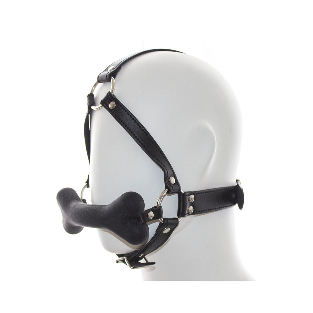 Ple'sur Face Harness Dog Bone Gag shown on a mannequin head, featuring a black harness and playful bone gag.