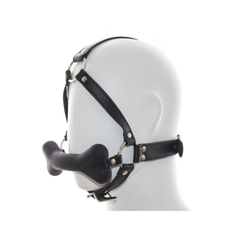Ple'sur Face Harness Dog Bone Gag shown on a mannequin head, featuring a black harness and playful bone gag.