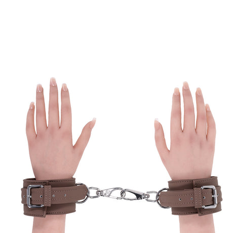 Sportsheets Signature Dawn Dream Handcuffs in smooth brown silicone with silver hardware connecting two hands.