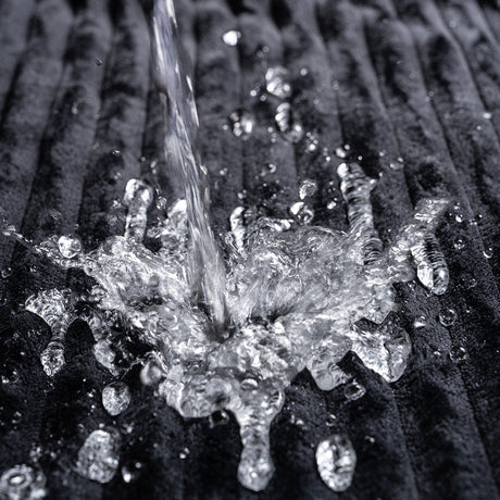 Water splashing on the Sportsheets Signature Waterproof Blanket, demonstrating its protective and waterproof features.