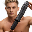 The Violator 13 Mode XL Dildo Thruster held by a model, showcasing its vein-textured design and substantial size.