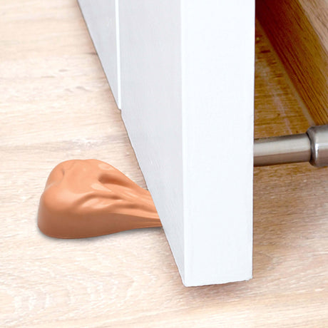 Big Balls Door Stop wedged under a door, providing a humorous and functional door-stopping solution.