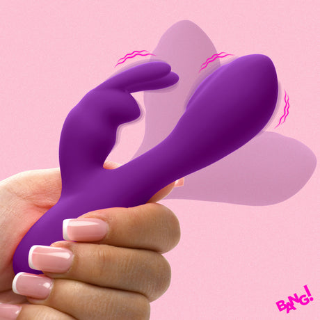 Flexible Vibrating Silicone Mini Rabbit Purple held in hand against a pink background.