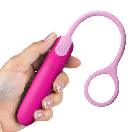 A hand holding the Bang Silicone Bullet with Cord Pink, showcasing its sleek design and retrieval cord for easy use.