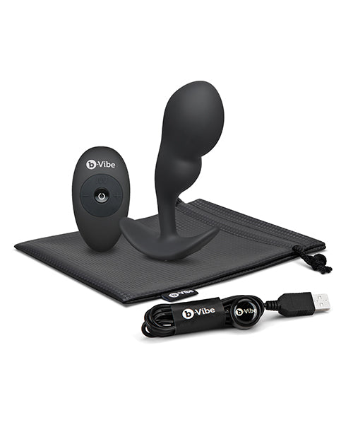 b-Vibe Remote Control P-Spot Snug Plug Black with remote and USB charging cable on storage pouch.