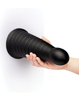 b-Vibe Cone 10 inch Tapered & Ribbed Dildo with Suction Cup held by a hand against a white background.