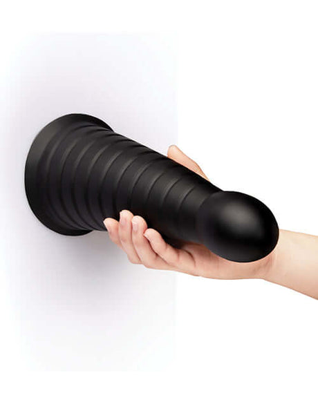 b-Vibe Cone 10 inch Tapered & Ribbed Dildo with Suction Cup held by a hand against a white background.