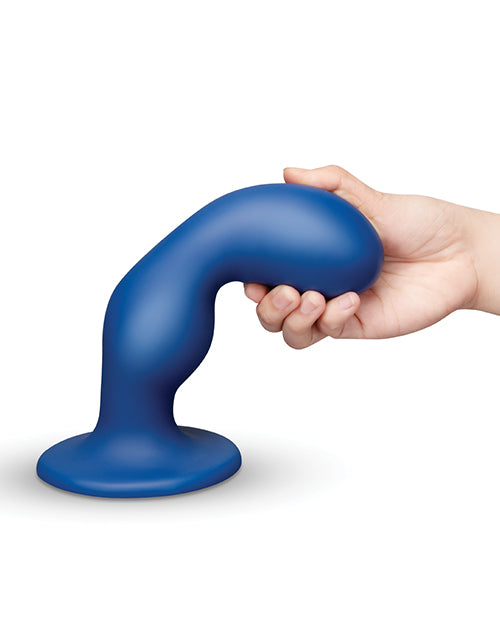 b-Vibe Milk 8.5 inch Curved Anal Trainer with Tapered Tip in blue held in hand for demonstration.