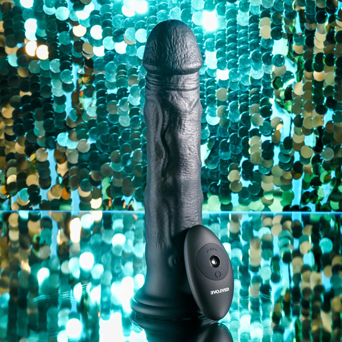 Evolved Black Thunder Vibrating Silicone Dildo Remote with textured shaft and remote control on a reflective surface.