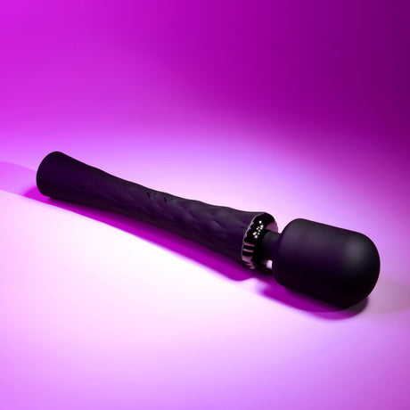 Playboy Royal Silicone Vibrating Wand Massager Black on a pink background showcasing its sleek design and functionality.
