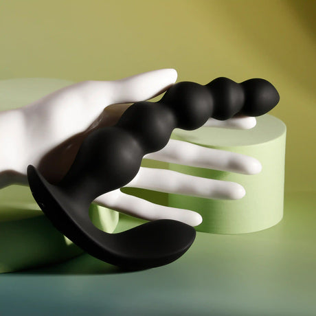 Evolved Bead Me Up Silicone Vibrating Anal Beads Black held in a hand, showcasing smooth, graduated curves.