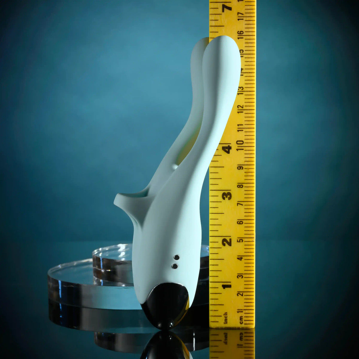 Evolved Couples Therapy Silicone Vibrator Green with a ruler for size comparison against a blue background.