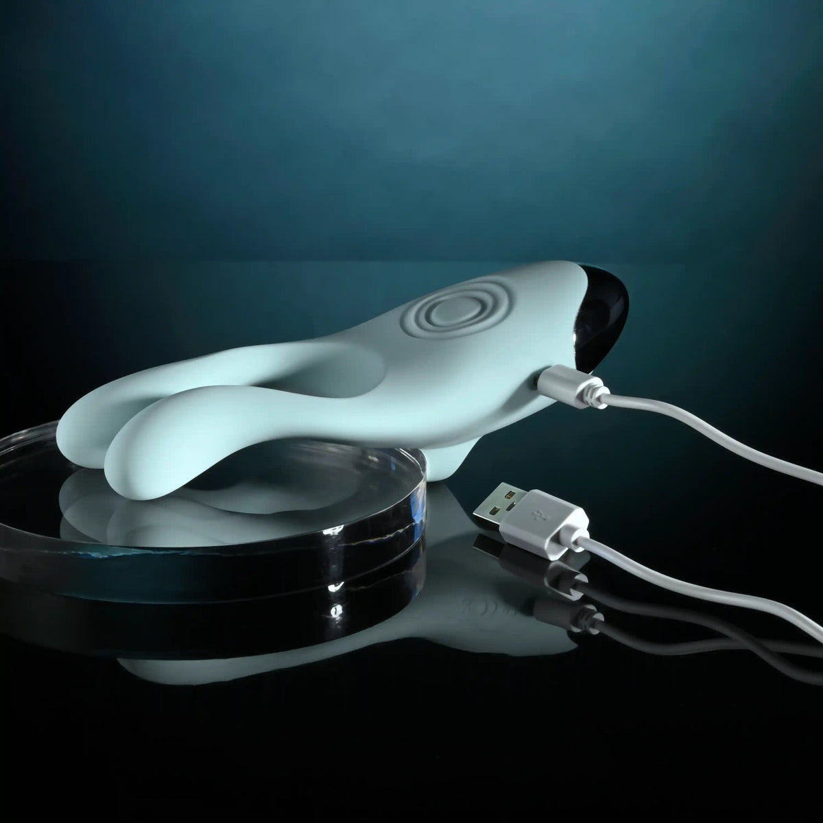 Evolved Couples Therapy Silicone Vibrator Green being charged with a USB cable, showcasing its sleek design.
