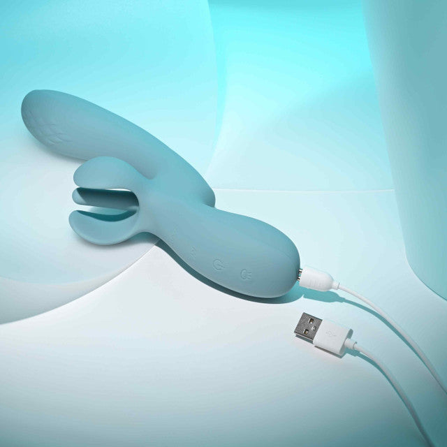 Evolved Take Your Flick Dual Motor Rabbit Vibrator in soft blue, connected for charging, showcasing its dual motor design.