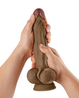 Shaft Model A Flexskin 10.5 Inch Dong with Balls Oak being held in hands, showcasing realistic texture and details.