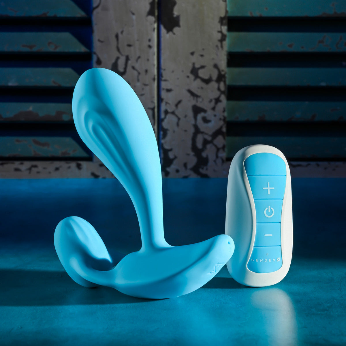 Gender X Wear Me Out Wearable Dual Vibrator Blue on a blue surface with control remote.