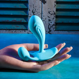 Gender X Wear Me Out Wearable Dual Vibrator Blue in a hand showcasing its ergonomic design and vibrant color.