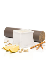 Jimmyjane Natural Massage Oil Candle 4.5 Oz Santal with lemon and spices on a yoga mat.