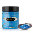 Kama Sutra Treasures Of The Sea Bath Salt jar with blue crystals and shell display beside it.