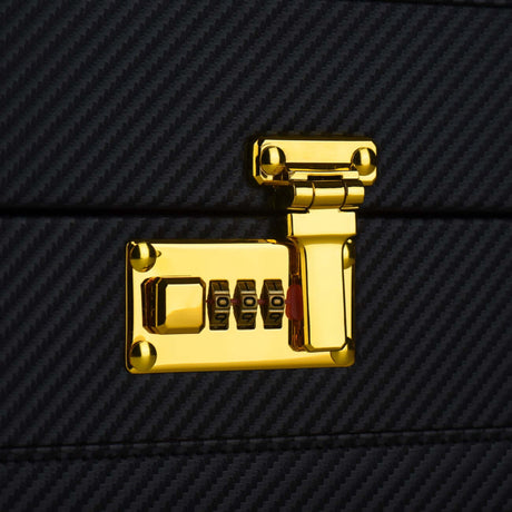 Gold combination lock on a luxury bondage trunk with sleek black texture.