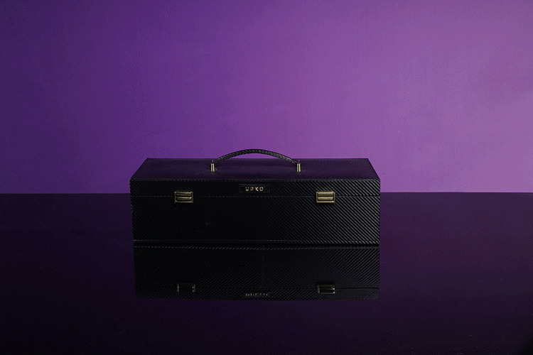 UPKO luxury black leather bondage tools case on a reflective surface with purple background. Ideal for BDSM accessories.