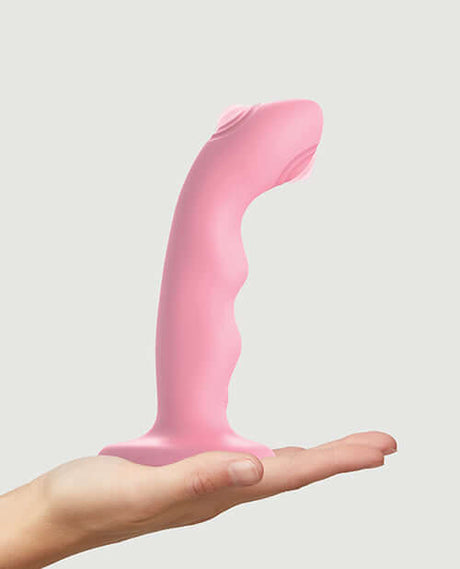 Strap-On-Me Tapping Dildo Wave Vibrator Coral displayed in a hand.