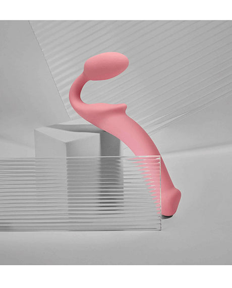 Strap-on-Me Semi-Realistic Bendable Strap-on Pink displayed on a minimalistic background with geometric shapes.