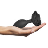 Love to Love Open Roses Silicone Butt Plug Black Onyx Large held in a hand, showcasing its elegant design and smooth surface.