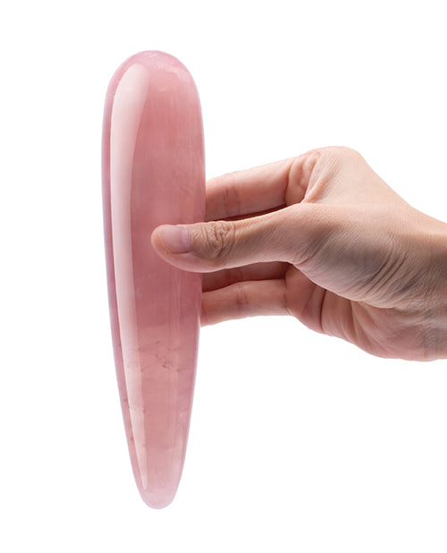 Le Wand Crystal Wand Rose Quartz Dildo held in hand, showcasing its elegant design and smooth surface.
