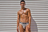 Male Power Peep Show Low Rise Thong White Small to Medium on a model showcasing a bold and revealing design.