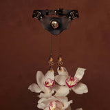 UPKO Mystic Bond Collection Collar with Pulling Nipple Clamps and orchids on a brown background.